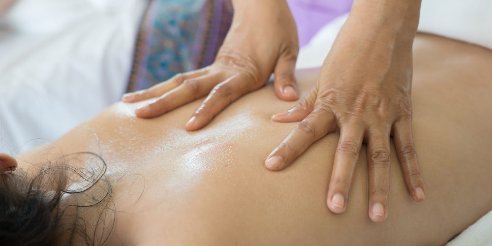 Beautiful woman having back massage and feeling visibly good.